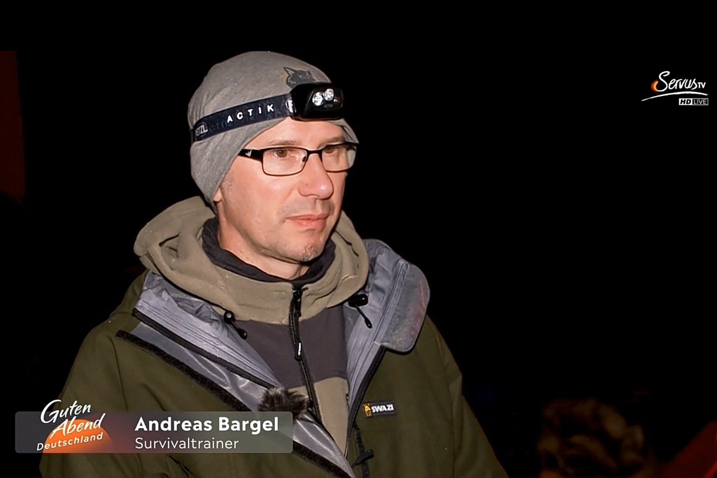 alt=“Andreas Bargel im Zuge einer Blackout Reportage bei Servus TV in einem nächtlichen Wald ″