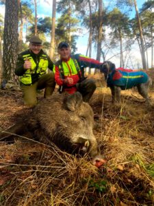 alt=“Jäger mit Hund und erlegtem Wildschwein für die Outdoorküche im Wald″